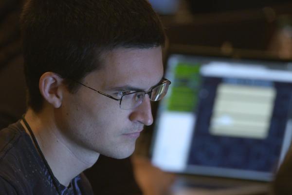 A man focusing intently on a computer laptop screen